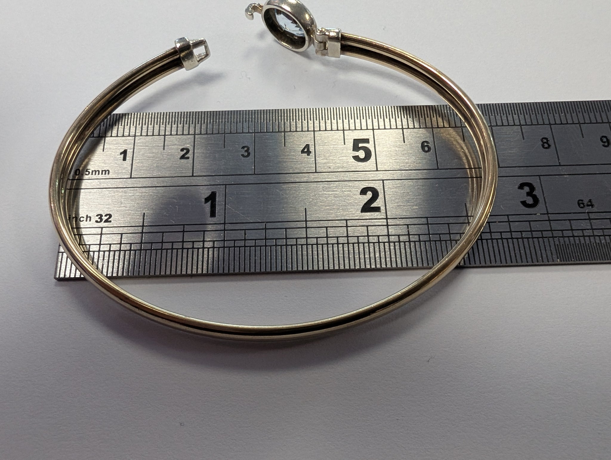 9ct gold bangle with light blue centre stone