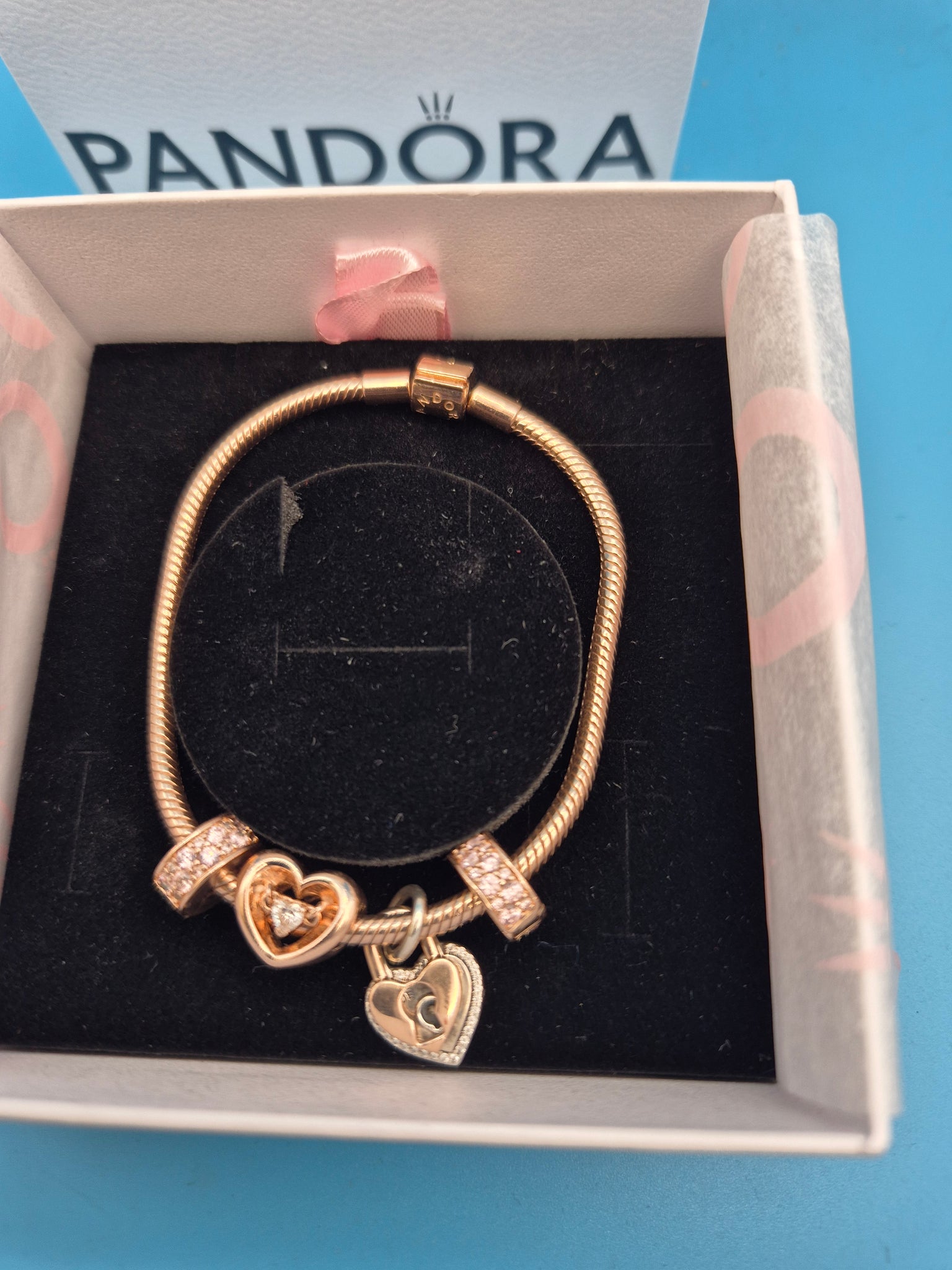 Pandora rose gold bracelet and charms.