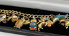 375 Hallmarked 9CT, YELLOW GOLD, 25X CHARMS ON CURBED BRACELET, 8", 35.1G, BOXED