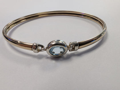 9ct gold bangle with light blue centre stone