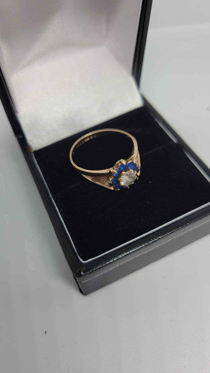 9ct Yellow Gold Ring With a White Stone (Not Dia) Surrounded With Blue Stones - Size M - 2.6 Grams.