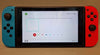 Nintendo Switch Console, 32GB + Neon Red/Blue Joy-Con (crack in screen protector, immaculate underneath)