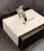 9ct Yellow Gold Crossover Ring Channel set with Light Blue Stones - Size M