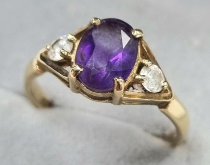 9CT GOLD RING WITH PURPLE STONE.