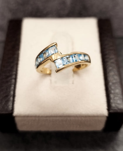9ct Yellow Gold Crossover Ring Channel set with Light Blue Stones - Size M