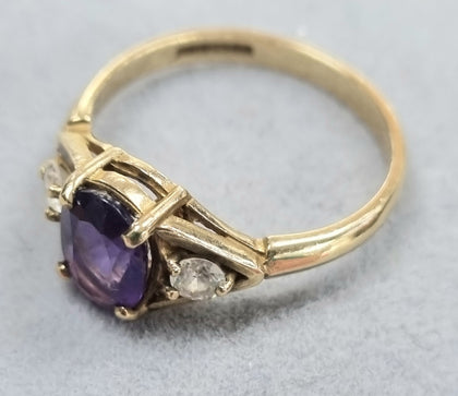 9CT GOLD RING WITH PURPLE STONE.