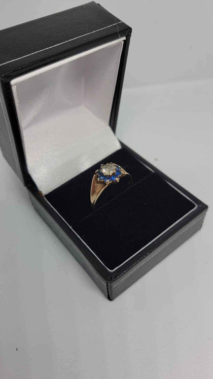 9ct Yellow Gold Ring With a White Stone (Not Dia) Surrounded With Blue Stones - Size M - 2.6 Grams.