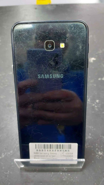 Samsung Galaxy j4 plus 32gb, black, open, has a white spot on screen and heavily scratches on back.